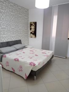 1 dormitorio con 1 cama con manta rosa y blanca en Casa vacanza Sofy, en Brindisi