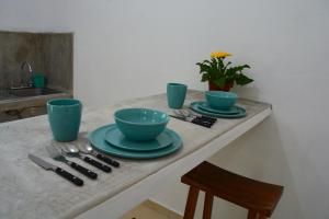 a table with two blue bowls and plates on it at Xula Bacalar in Bacalar +29 photos