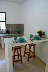 eine Küche mit einem Tisch mit blauen Schüsseln darauf in der Unterkunft Xula Bacalar in Bacalar