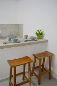 a kitchen counter with two stools and a sink at Xula Bacalar in Bacalar