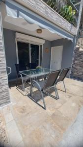 a glass table and chairs on a patio at Plaza House in Kanakia