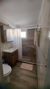 ein Bad mit einer Dusche, einem WC und einem Waschbecken in der Unterkunft Plaza House in Kanáki