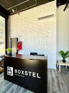 a reception desk with a boxsed sign on a wall at Boxstel - Modern Stay Hotel Downtown El Paso in El Paso