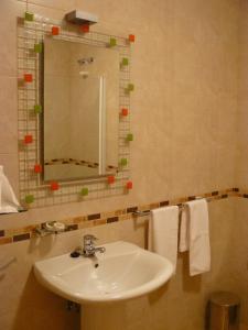 La salle de bains est pourvue d'un lavabo, d'un miroir et de serviettes. dans l'établissement A Feira Posada, à Overo