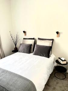 um quarto com uma cama branca e 2 almofadas em MARAIS BRAQUE APPARTEMENT em Paris