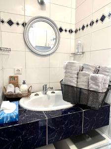 een badkamer met een wastafel en een spiegel bij MARAIS BRAQUE APPARTEMENT in Parijs