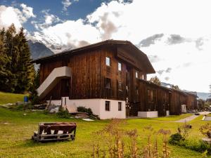 a large wooden barn with a cow in front of it at Auberge de Jeunesse HI Chamonix in Chamonix-Mont-Blanc