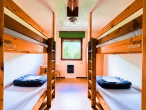 two bunk beds in a room with a window at Auberge de Jeunesse HI Chamonix in Chamonix-Mont-Blanc