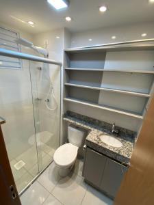 uma casa de banho com um chuveiro, um WC e um lavatório. em Apartamento com Sacada na Gleba, Novo e equipado em Londrina