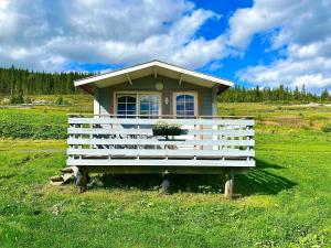 a white wooden bench sitting in the middle of a grassy field at Aspnes Camping AS in Mosjøen