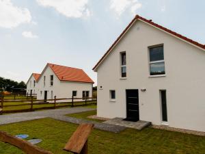 two white houses in a yard with a wooden bench at Mazury Zakątek Salpia 1 dom apartament 10 osób Family 1 in Prażmowo
