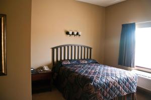 a bedroom with a bed and a desk and a window at Americas Best Value Inn Big Lake Becker in Big Lake
