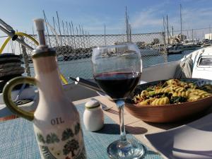 a glass of wine and a bowl of food on a table at La tua stanza a vela sul mare in Bari