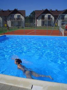a woman laying in a swimming pool at apartament Jaśkowy in Żarnowska