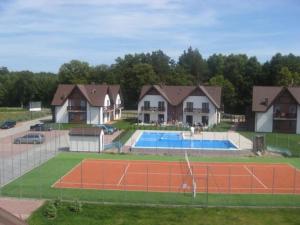 uma casa com um campo de ténis em frente a uma casa em apartament Jaśkowy em Żarnowska