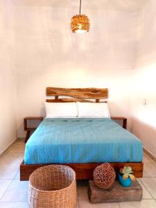 een slaapkamer met een bed met een blauw dekbed en 2 manden bij Casa Mayab Bacalar in Bacalar