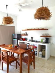 een keuken met een houten tafel met stoelen en een laptop bij Casa Mayab Bacalar in Bacalar