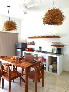 cocina con mesa de madera con sillas y ordenador portátil en Casa Mayab Bacalar en Bacalar