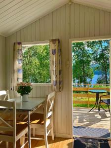 a dining room with a table and chairs and a patio at Aspnes Camping AS in Mosjøen