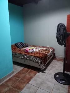 een slaapkamer met een bed in een kamer met een ventilator bij La casita de abu! in Salta