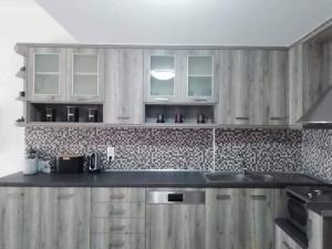 プラキアスにあるHOTEL LOFOS APARTMENTのキッチン(木製キャビネット、黒いカウンタートップ付)