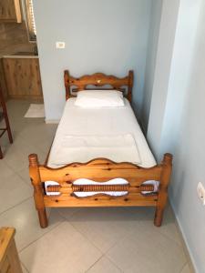 a wooden bed sitting in a corner of a room at Vila Bedro in Sarandë