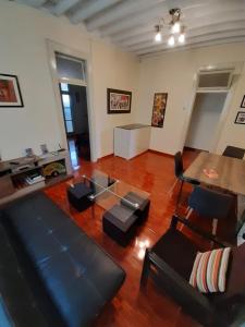 uma sala de estar com um sofá, uma mesa e cadeiras em HEART OF PLAZA SAN MARTIN - 2 Boutique Apartments em Lima