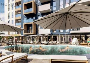 a swimming pool with people in it with an umbrella at Studio Philip by Alezzii Nord 10 in Năvodari