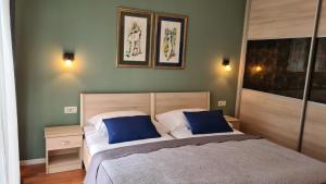 a bedroom with two beds and two pictures on the wall at Villa Amalia Apartment 2 in Malinska