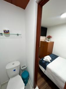Dormitorio pequeño con cama y aseo en Hostal Casa del Café, en Bogotá