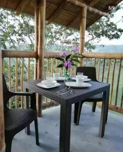 una mesa negra y sillas en un porche con mesa y flores en Alojamiento rural finca la bendición, en Filandia