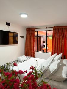 1 dormitorio con cama y ventana grande en Hostal Casa del Café, en Bogotá