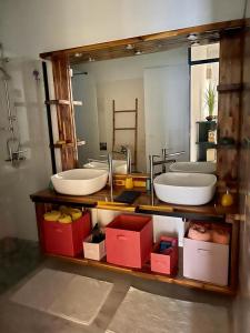 La salle de bains est pourvue de 2 lavabos et d'un grand miroir. dans l'établissement Bas de Villa ALPINIA au Gosier, au Gosier