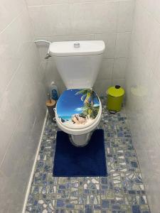 a bathroom with a toilet with a beach on the seat at Bas de Villa ALPINIA au Gosier in Le Gosier