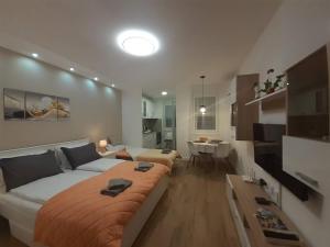 a bedroom with a large bed and a living room at Apartments Biro in Subotica