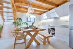 a kitchen with a wooden table and chairs at The Violin House in Chania