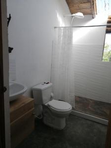 y baño blanco con aseo y ducha. en Alojamiento rural finca la bendición, en Filandia