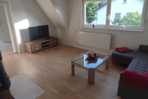 sala de estar con sofá y mesa de centro en Top Ferienwohnung am Waldrand mit großem Balkon, en Lübbecke