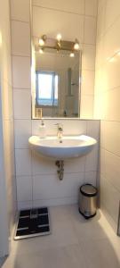 a bathroom with a sink and a mirror at Top Ferienwohnung am Waldrand mit großem Balkon in Lübbecke
