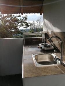a kitchen counter with a sink and a window at Alojamiento rural finca la bendición in Filandia