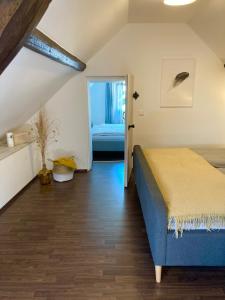 ein Schlafzimmer mit einem blauen Bett in einem Zimmer in der Unterkunft Ferienhaus Goldstück wohnen im Weinberg in Pommern