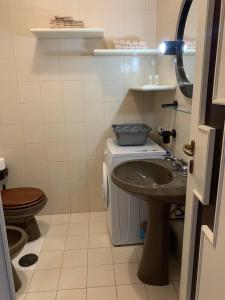 a bathroom with a sink and a toilet at Sunset Apartment in Santa Marinella +32 photos
