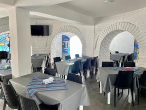 a dining room with tables and chairs and a tv at HOTEL CAASAMA in Santa María