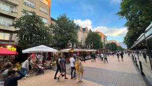 een groep mensen die door een straatmarkt lopen bij Heart of the City Center Lux Apartment with View in Sofia