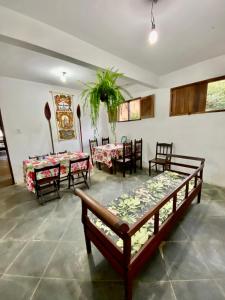 uma sala de jantar com mesas, cadeiras e bancos em Hostel Dona Generoza em Paraty