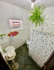 a bathroom with a toilet and a plant in it at Hostel Dona Generoza in Paraty