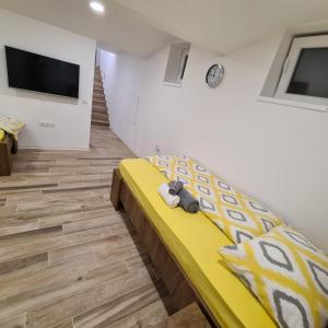 a bedroom with a yellow bed with a teddy bear on it at Apartment DINLUX in Maribor