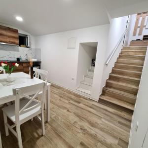 a kitchen and dining room with a white table and stairs at Apartment DINLUX in Maribor