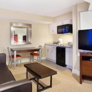 a living room with a couch and a table and a kitchen at Boardwalk Resorts at Atlantic Palace in Atlantic City