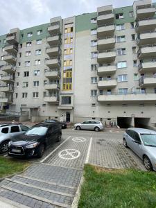 a parking lot with cars parked in front of a building at Apartamenty Nila in Kraków